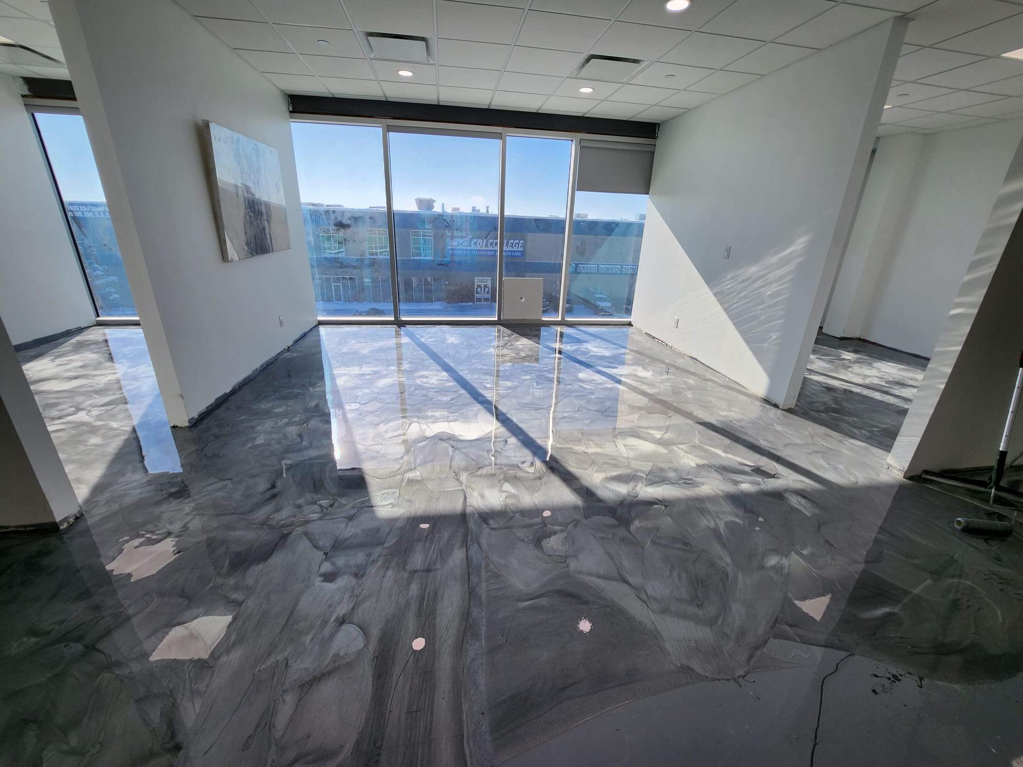 Office space with grey metallic epoxy floor and large windows