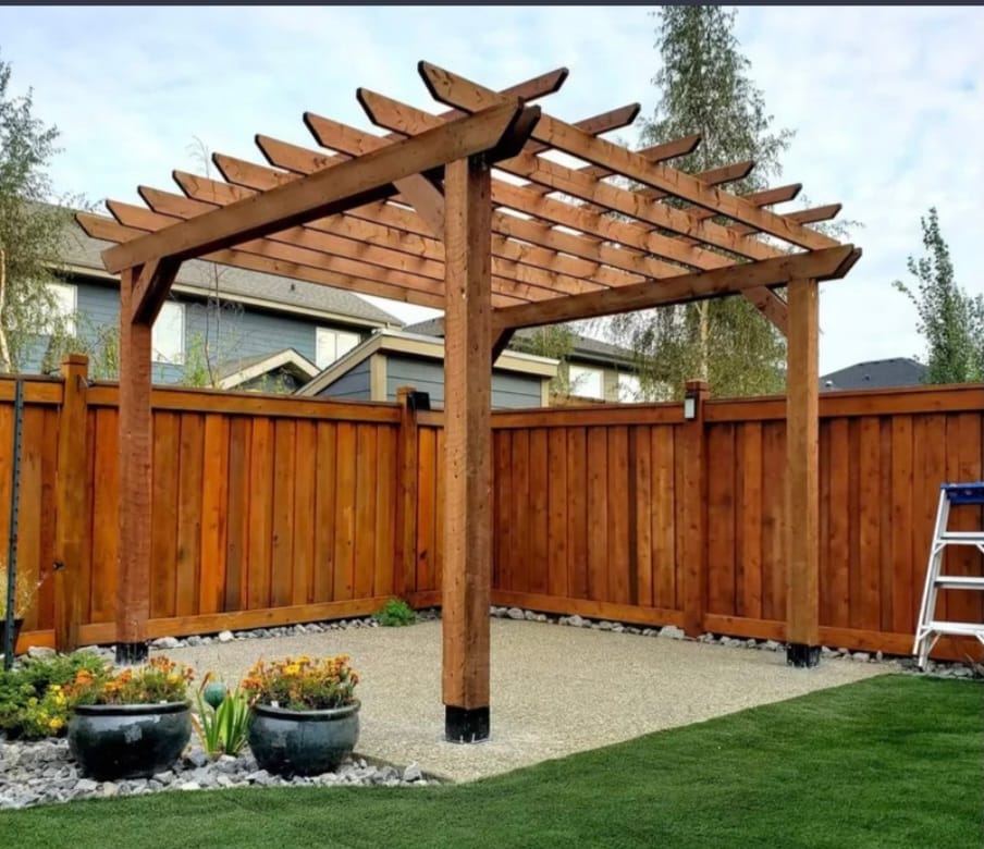 Stained cedar pergola over a gravel patio with matching privacy fence